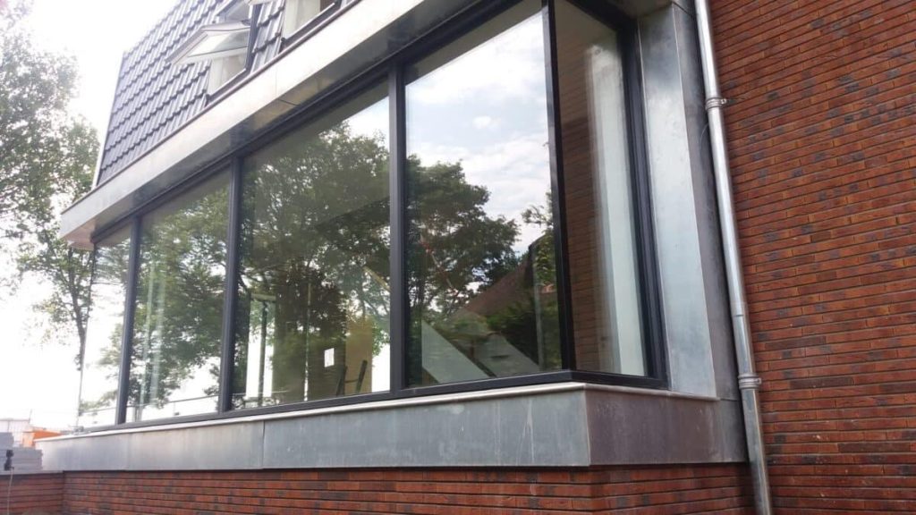 Moderne woning met grote aluminium kozijnen en schuifpuien die veel daglicht binnenlaten en de ruimte groter doen voelen
